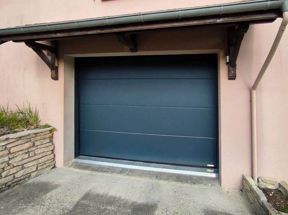Façade extérieure de garage résidentiel moderne avec deux portes sectionnelles en acier gris anthracite fermées